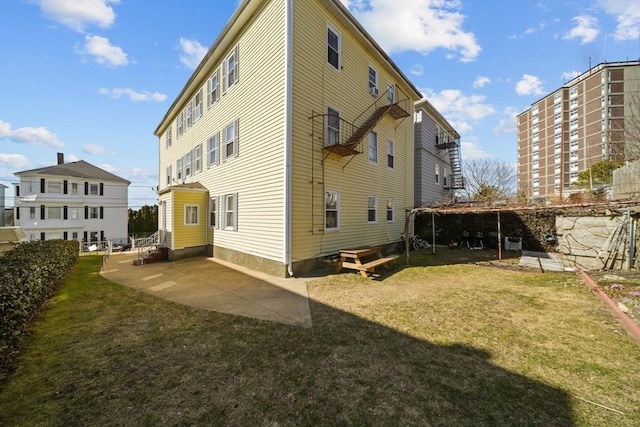 rear view of property featuring a yard and a patio