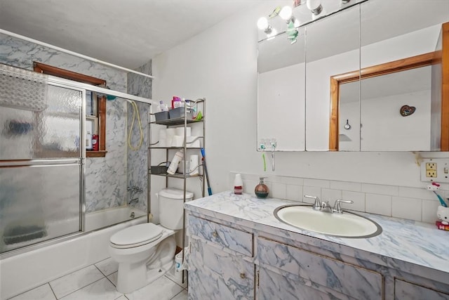 bathroom with bath / shower combo with glass door, vanity, and toilet