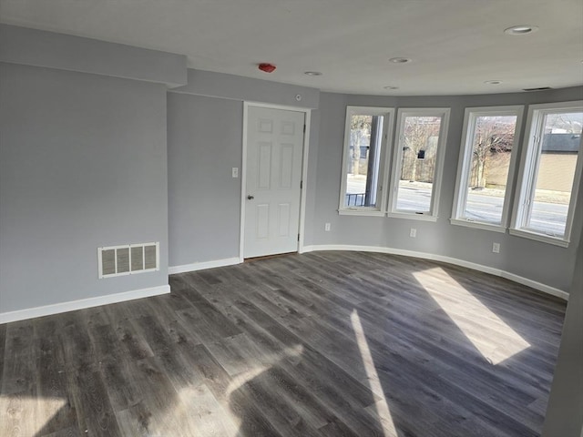 spare room with recessed lighting, visible vents, dark wood finished floors, and baseboards