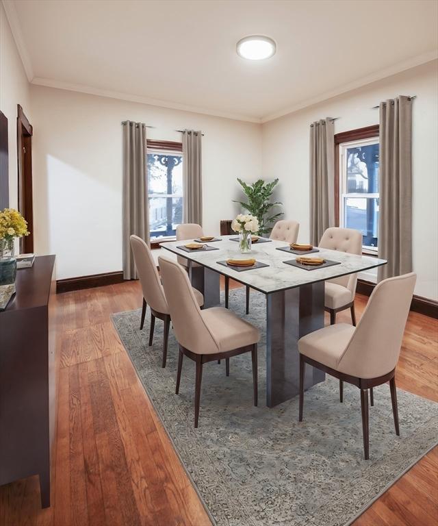 dining space with ornamental molding, wood finished floors, and baseboards