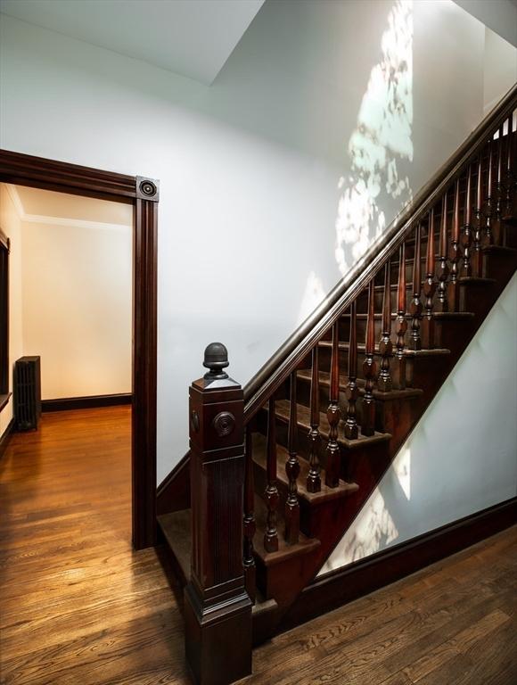 stairway with wood finished floors and baseboards