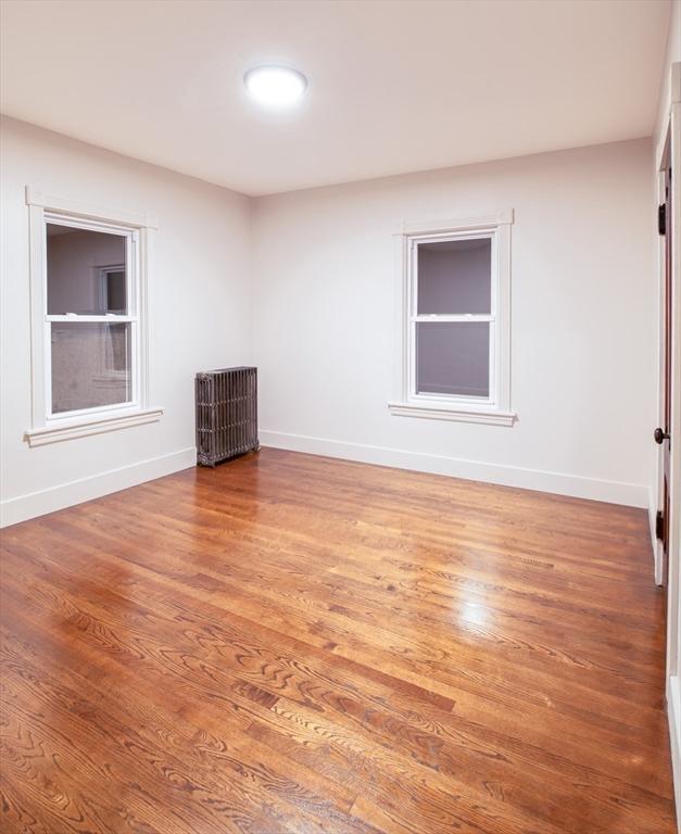 spare room featuring baseboards and wood finished floors