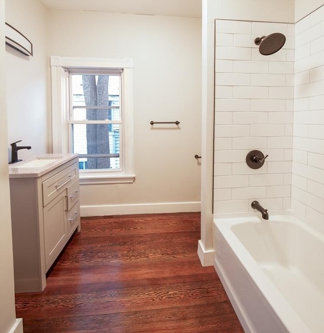 bathroom with shower / bathing tub combination, vanity, baseboards, and wood finished floors