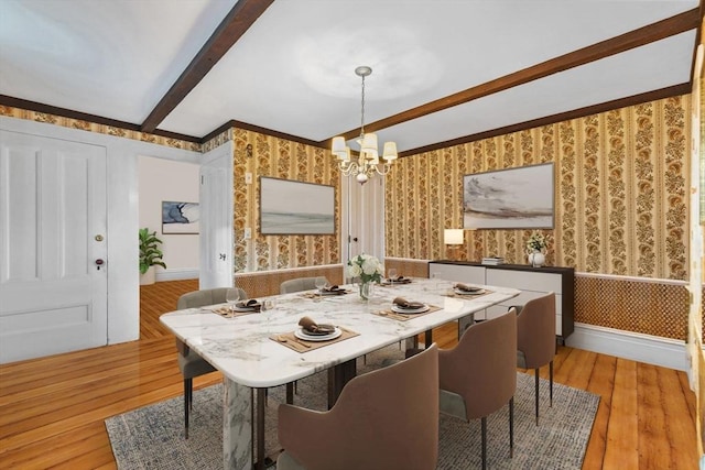 dining room with beam ceiling, a chandelier, and light wood-type flooring