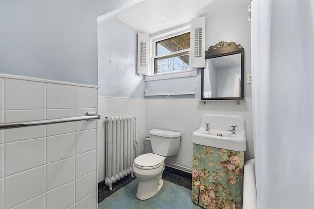 bathroom featuring radiator, tile walls, and toilet