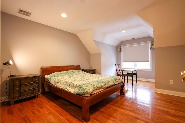 bedroom featuring lofted ceiling, recessed lighting, wood finished floors, visible vents, and baseboards