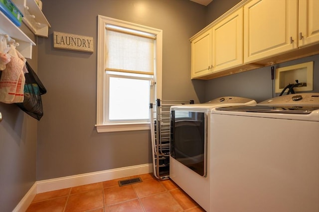 washroom with washing machine and dryer, cabinet space, visible vents, and light tile patterned flooring