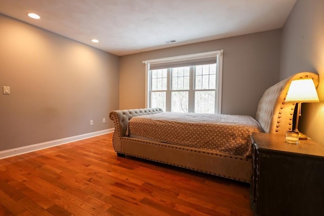 bedroom with recessed lighting, visible vents, baseboards, and wood finished floors