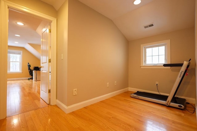 workout room with baseboards, visible vents, vaulted ceiling, light wood-type flooring, and recessed lighting