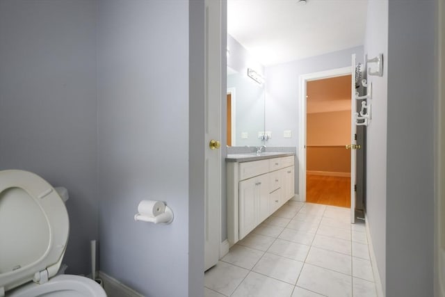 bathroom featuring vanity, tile patterned flooring, toilet, and baseboards