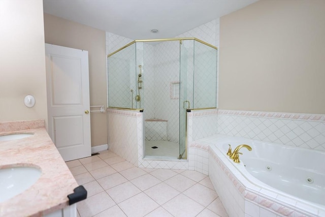 full bathroom featuring a jetted tub, a stall shower, tile patterned flooring, and a sink