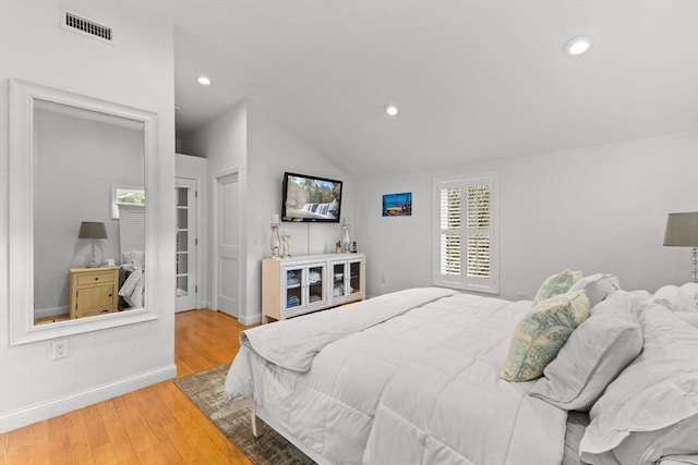bedroom with recessed lighting, visible vents, vaulted ceiling, and wood finished floors