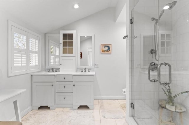 full bath with a stall shower, double vanity, a sink, and lofted ceiling