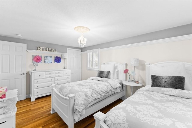 bedroom with light wood-type flooring and a notable chandelier