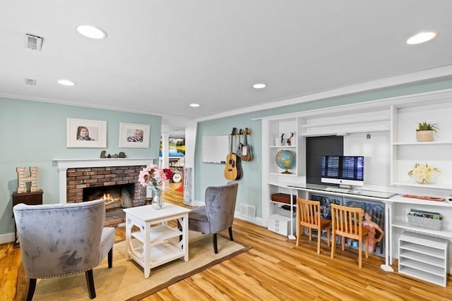 living area featuring visible vents, recessed lighting, wood finished floors, and a fireplace