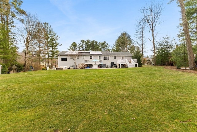 rear view of property featuring a deck and a lawn