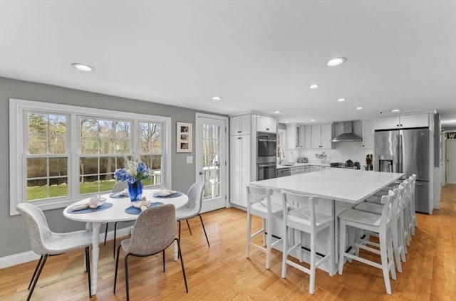 dining space featuring light wood-type flooring, baseboards, and recessed lighting