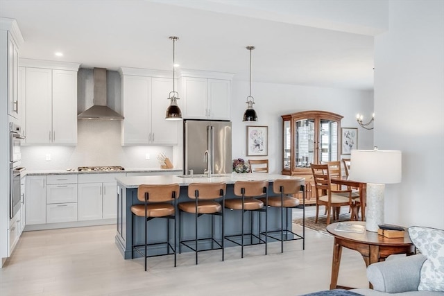 51 Tinkers Blf Unit 51, Plymouth, MA 02360 - kitchen featuring appliances with stainless steel finishes, wall chimney exhaust hood, a sink, decorative backsplash, and white cabinetry