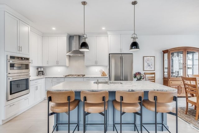51 Tinkers Blf Unit 51, Plymouth, MA 02360 - kitchen featuring appliances with stainless steel finishes, wall chimney exhaust hood, backsplash, a kitchen breakfast bar, and an island with sink