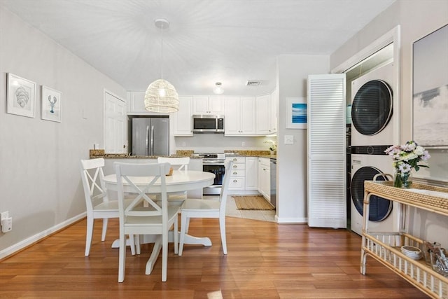 2 Englewood Dr Unit F-6, Harwich, MA 02645 - dining space featuring stacked washing machine and dryer and light wood-type flooring