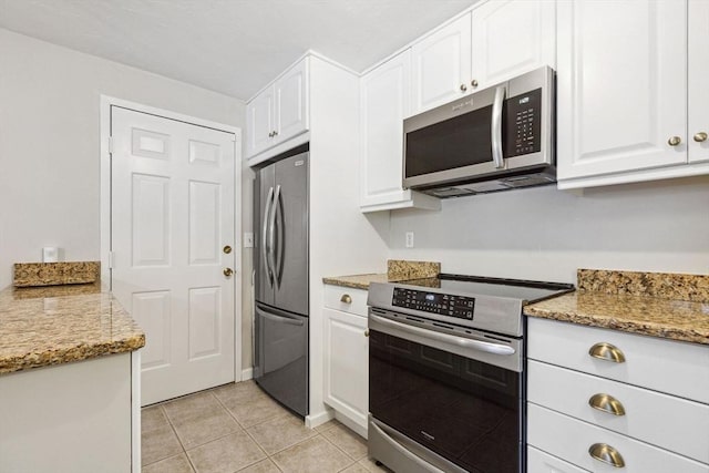 2 Englewood Dr Unit F-6, Harwich, MA 02645 - kitchen featuring appliances with stainless steel finishes, white cabinetry, light tile patterned floors, and light stone counters