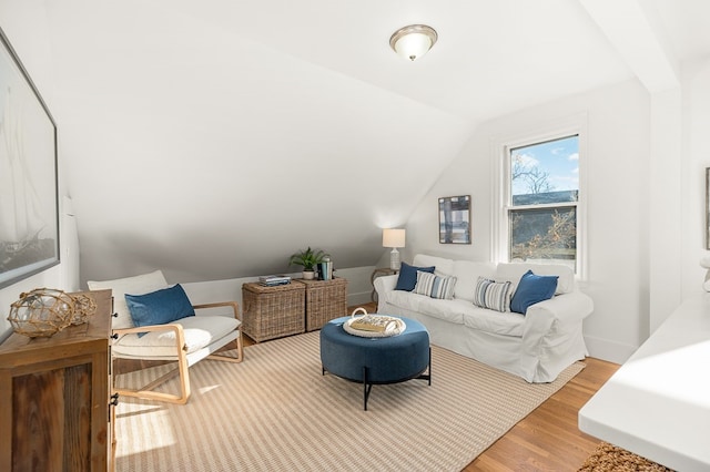 living room with light hardwood / wood-style floors and vaulted ceiling