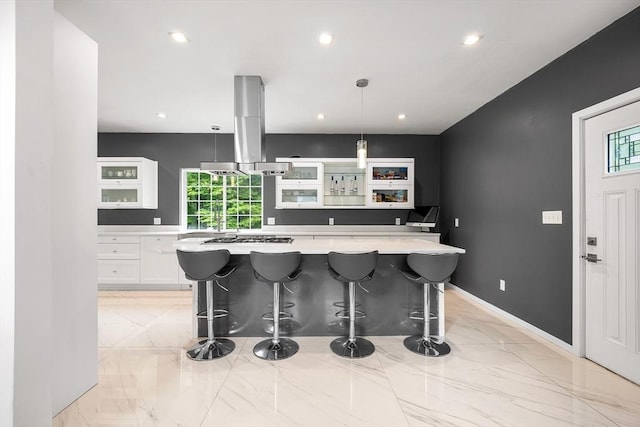 24 Clark St, Taunton, MA 02780 - kitchen featuring island range hood, white cabinets, light countertops, light marble finish flooring, and a kitchen breakfast bar