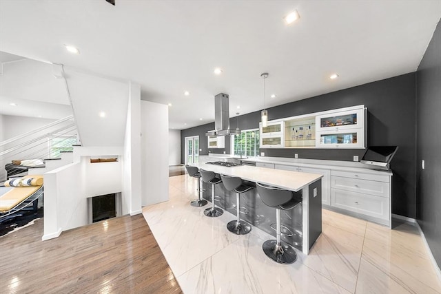24 Clark St, Taunton, MA 02780 - kitchen with island exhaust hood, white cabinets, light countertops, a kitchen bar, and a spacious island