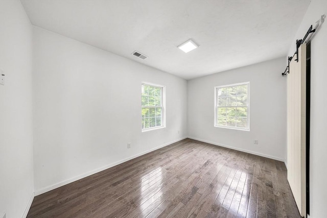 24 Clark St, Taunton, MA 02780 - spare room with a barn door, hardwood / wood-style floors, and baseboards