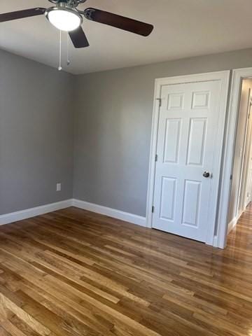 unfurnished bedroom featuring ceiling fan, baseboards, and wood finished floors