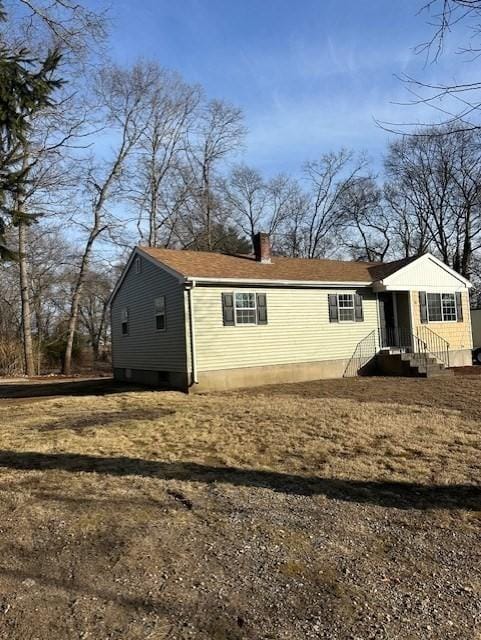 rear view of house featuring entry steps and a chimney