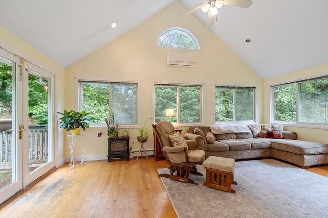22 Tenney St, Georgetown, MA 01388 - living area with baseboard heating, high vaulted ceiling, light wood-type flooring, ceiling fan, and a wood stove