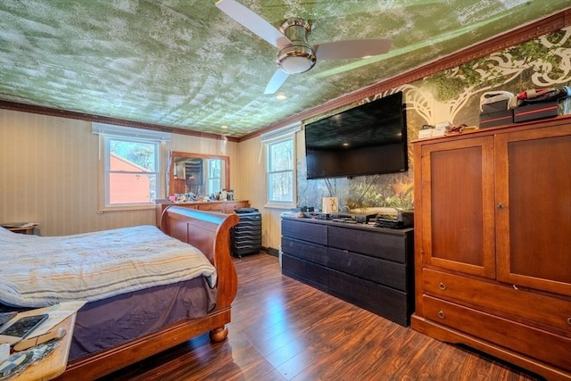 bedroom featuring ceiling fan, ornamental molding, and dark hardwood / wood-style floors