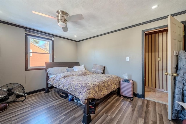 bedroom featuring ceiling fan, a textured ceiling, hardwood / wood-style flooring, and crown molding