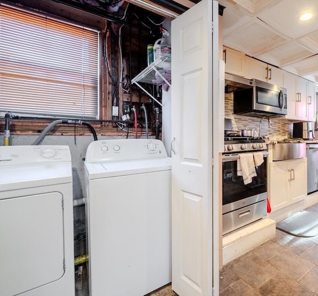 clothes washing area featuring washing machine and dryer and light tile patterned flooring