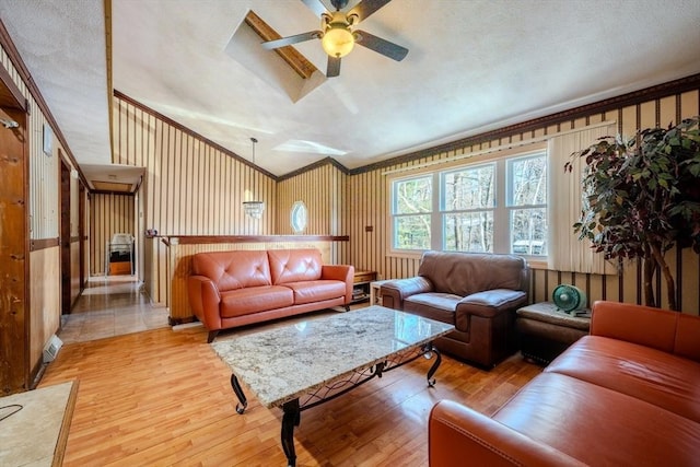 living room with ceiling fan, ornamental molding, and light hardwood / wood-style floors