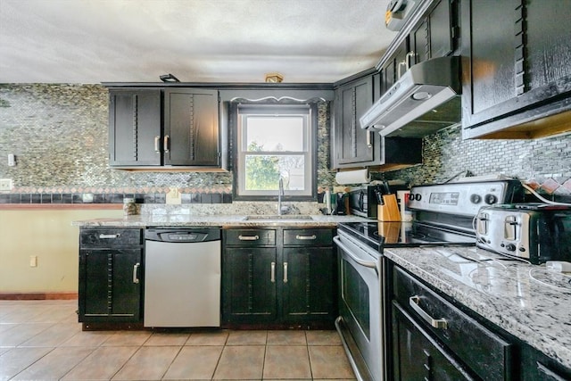 kitchen with light stone countertops, stainless steel appliances, sink, backsplash, and light tile patterned flooring