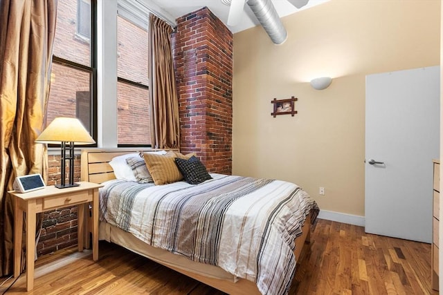 bedroom featuring baseboards and wood finished floors