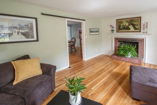 living room featuring a brick fireplace and light hardwood / wood-style flooring