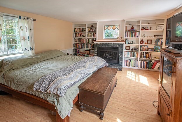 bedroom featuring light hardwood / wood-style floors and a fireplace