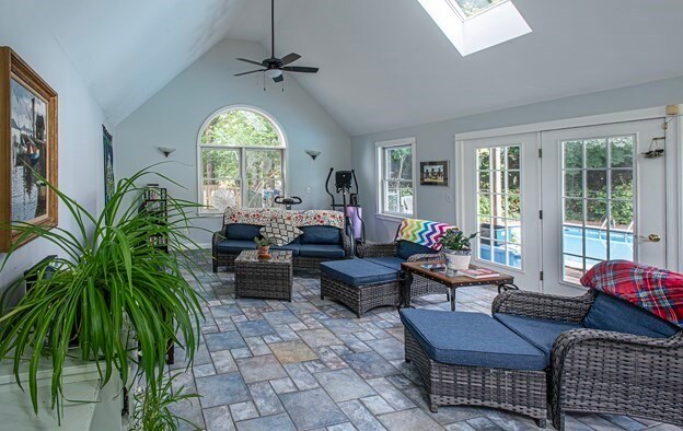 interior space with ceiling fan, a skylight, and high vaulted ceiling