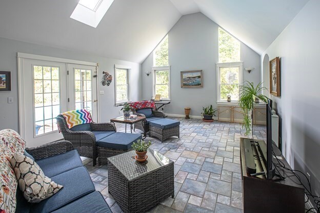 living room with a skylight and high vaulted ceiling