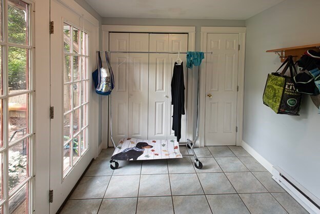 exercise room with a baseboard radiator and light tile patterned flooring