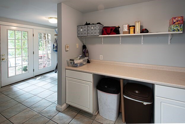 kitchen featuring light tile patterned flooring and white cabinetry