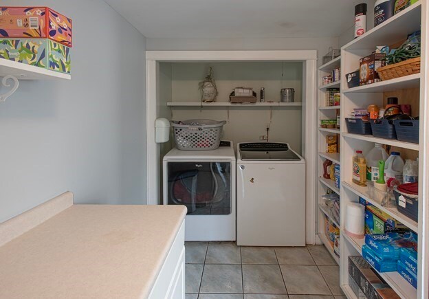 laundry room featuring separate washer and dryer and light tile patterned floors