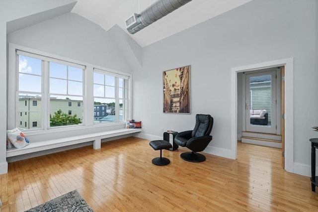 sitting room with vaulted ceiling and light wood-type flooring