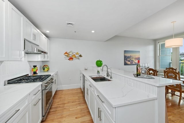 kitchen with sink, decorative light fixtures, kitchen peninsula, and appliances with stainless steel finishes