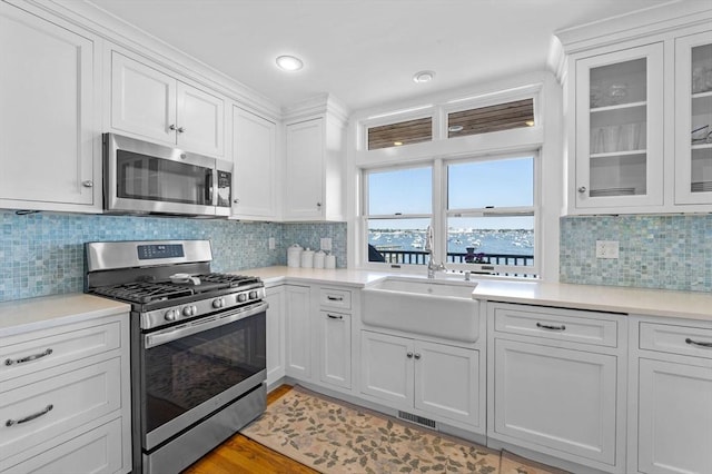 kitchen with stainless steel appliances, white cabinets, and light countertops