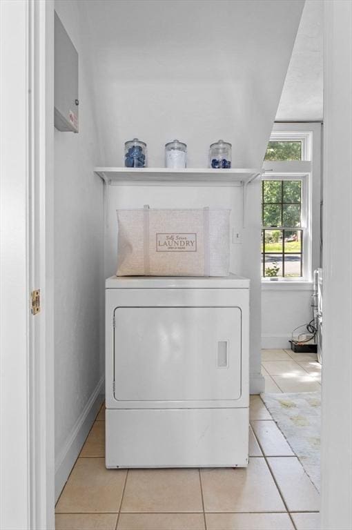 laundry area featuring washer / dryer, light tile patterned floors, and baseboards