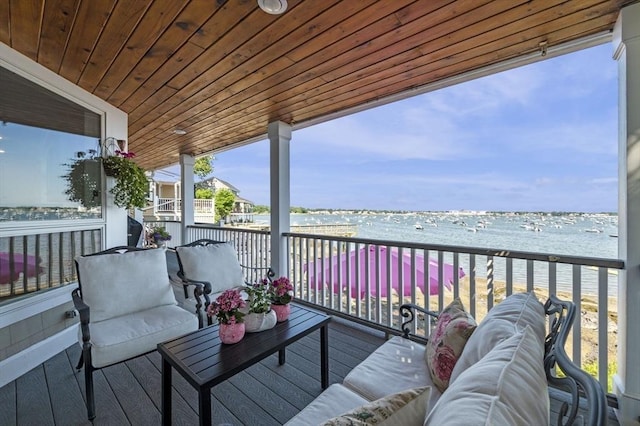 wooden terrace featuring a water view and an outdoor hangout area